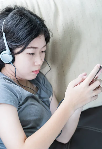 Asiatico donna ascolto musica da cellulare — Foto Stock