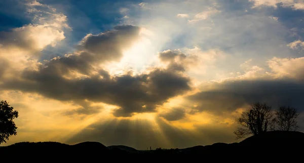 Puesta de sol panorámica con nubes en el crepúsculo cielo con s montaña — Foto de Stock