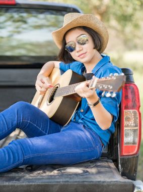 Kadın giyim şapka ve gitar çalmak kamyonet üzerinde