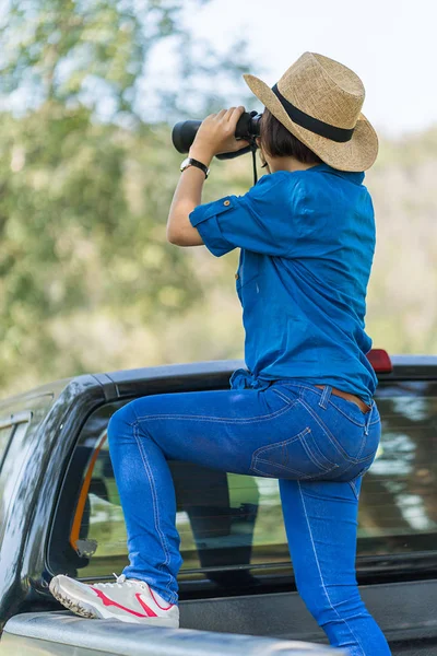Detailní záběr žena nosit klobouk a držte binokulární v travnaté hřiště — Stock fotografie