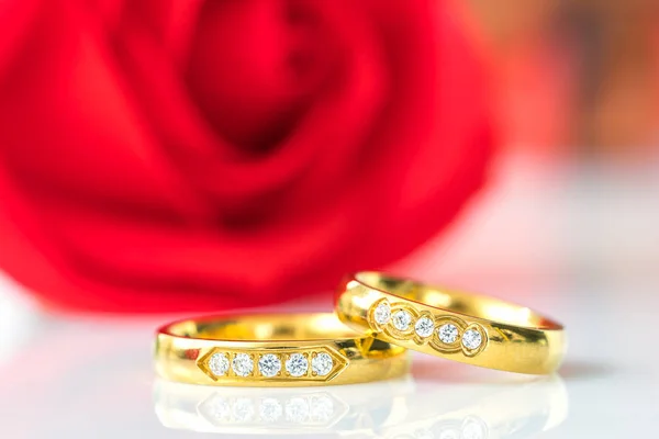 Close up Rose rosse e anelli d'oro su bianco — Foto Stock