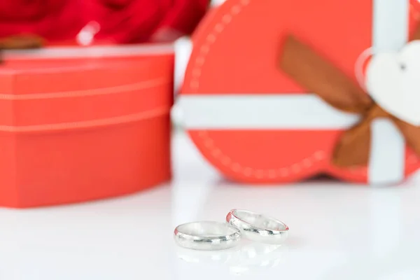 Anel de casamento e caixa em forma de coração no branco — Fotografia de Stock