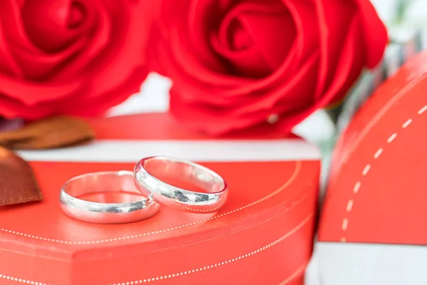 Anel de casamento e caixa em forma de coração no branco — Fotografia de Stock