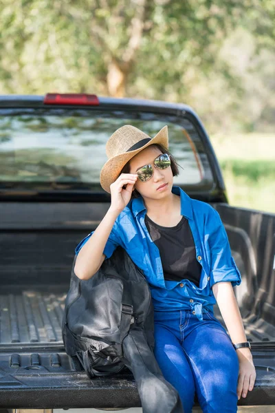 Žena nosí klobouk a její kytarové pouzdro na pick-up — Stock fotografie