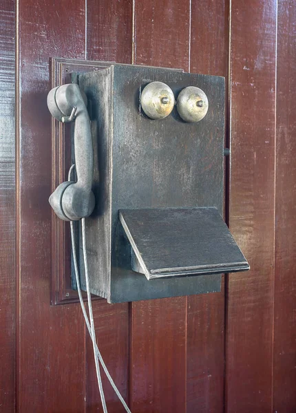 Antigo telefone velho pendurar na parede de madeira — Fotografia de Stock