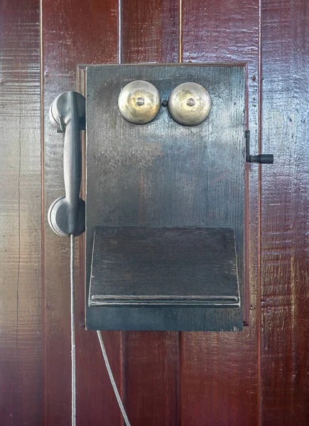 Старый старинный телефон висит на деревянной стене — стоковое фото