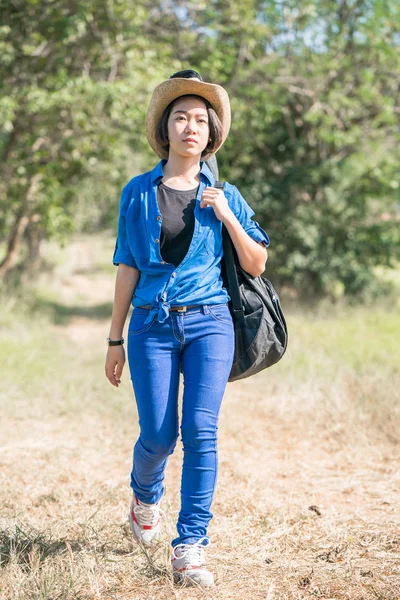 Mujer usar sombrero caminando y llevar su bolsa de guitarra —  Fotos de Stock