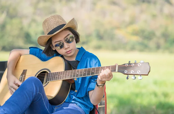 Kvinnan bär hatt och spela gitarr på pickup lastbil — Stockfoto