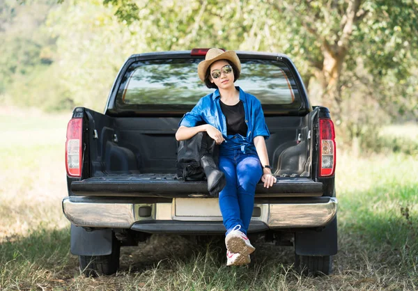 Žena nosí klobouk a její kytarové pouzdro na pick-up — Stock fotografie