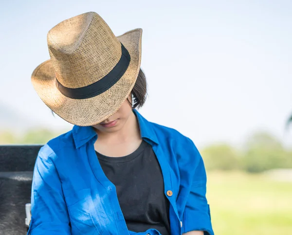 Mujer usar sombrero sentarse a dormir en el campo —  Fotos de Stock