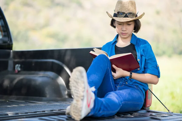 Woman wear hat and reading the book on pickup truck — Stock Photo, Image