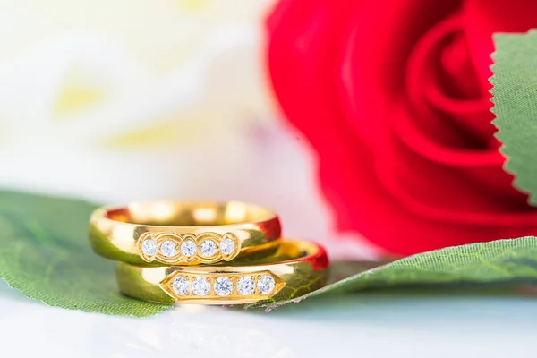 Feche o anel de ouro e rosas vermelhas no branco — Fotografia de Stock