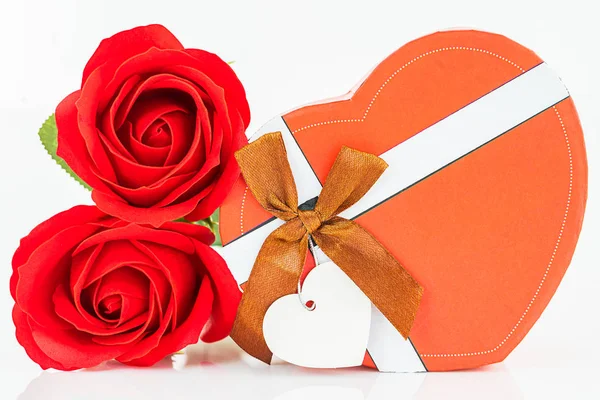 Red roses and heart shaped box on white — Stock Photo, Image