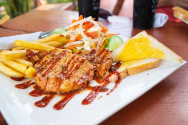 Tabakta salata ile ızgara domuz eti.