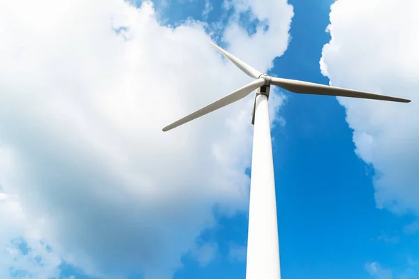 Wind turbine against a cloudy blue sky — Stock Photo, Image