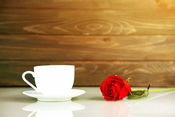 Red roses and coffee cup on table with copy space