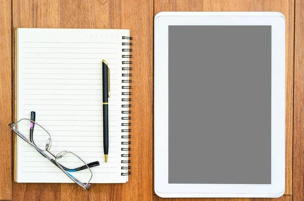 Dijital tablet, ahşap güvertede gözlük ve not defteri ile taklit edilir.