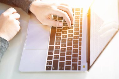 Ev ofisinde çalışan bir kadın dizüstü bilgisayarla arama ağı ve internet tarayıcısı kullanıyor.