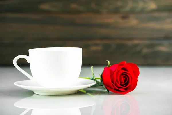 Rote Rosen und Kaffeetasse auf dem Tisch mit Kopierraum — Stockfoto