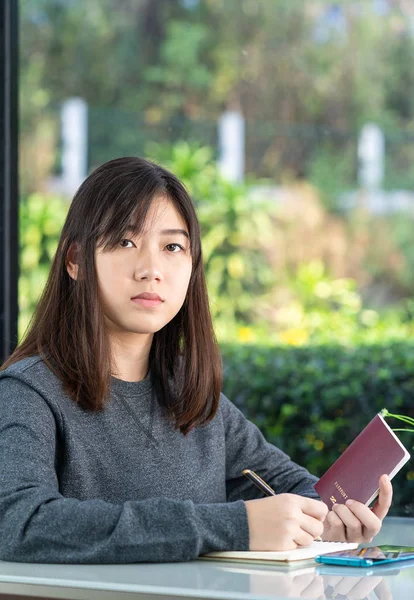 Mujer joven sentada con pasaporte y tarjeta de crédito —  Fotos de Stock