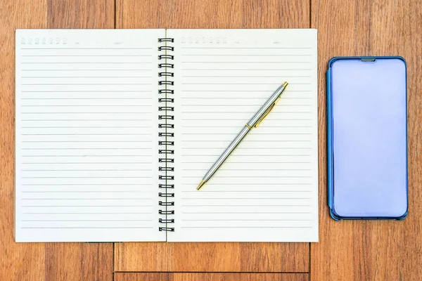 Bild von oben von geöffnetem Notizbuch mit leeren Seiten und Handy o — Stockfoto