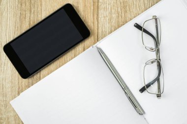 Cep telefonu ve gözlüklü boş defter günlüğü