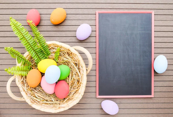 Easter eggs in basket and blackboard