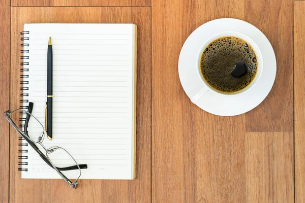 Eyeglasse and notepad with coffee cup on wood deck — Stock Photo, Image