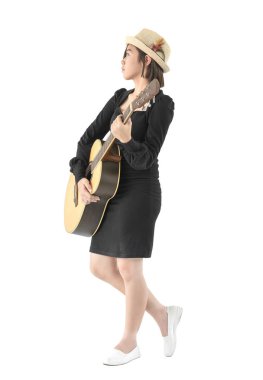 Genç Asyalı kadın gitar türküsünü elinde tutuyor beyaz arka planda izole ediyor.