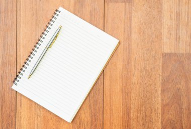 Tahta güvertede kopyalanmış kalem ve not defteri