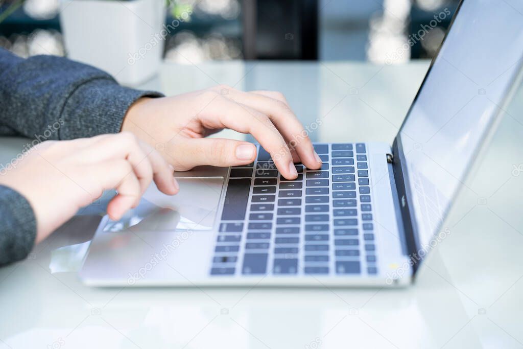 Woman working at home office using laptop searching web, browsing information ,Hand on keyboard close up