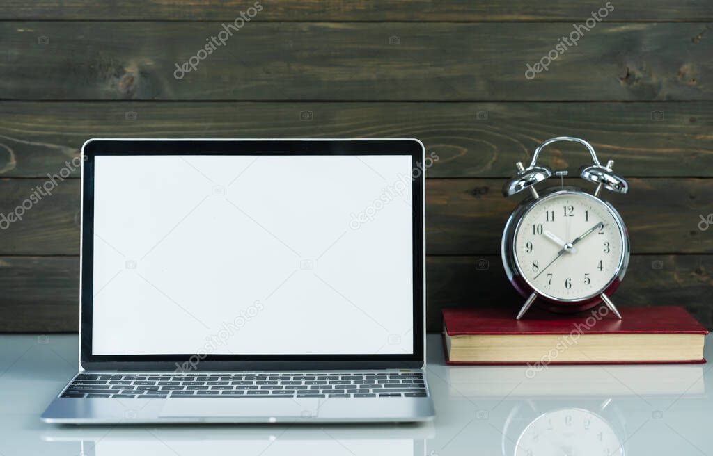 Front view of Laptop mockup and alarm clock with wood background on the work table