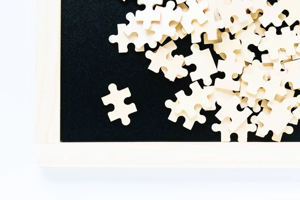 Close up Shot of wooden jigsaw puzzle pieces on black background,Business concept