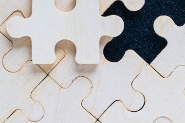 Tahta yapboz parçaları, siyah arka plan, iş konsepti.