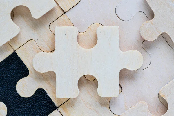 Shot of wooden jigsaw puzzle pieces on black background,Business concept