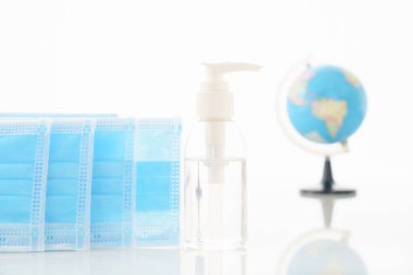 Alkol jeli şişesi ve cerrahi maske, güvertede antibakteri ve virüs koruması için tıbbi maske.