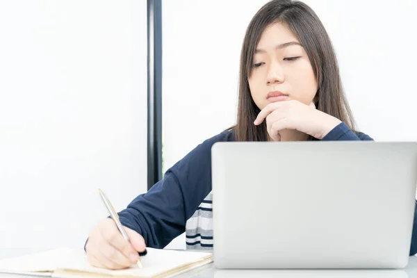 여학생 거실에 앉아서 노트북으로 책상에서 인터넷 학습을 있습니다 — 스톡 사진