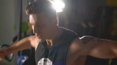 Spor salonunda. Yakışıklı adam trenler görünümünü simülatör