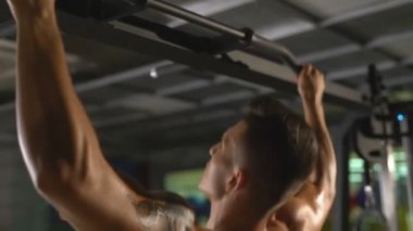 Spor salonunda. Terli adam acına üzerinde yukarı çekerek görünümünü