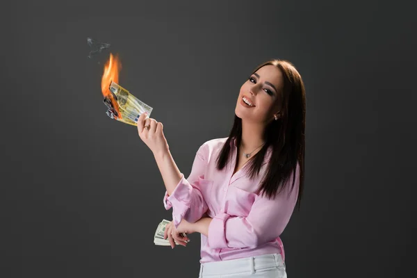 Menina sorridente queima dinheiro. Conceito de extravagância — Fotografia de Stock