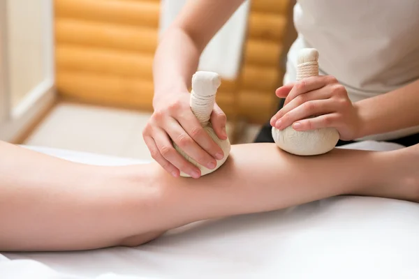 Masseuse doing thai massage with salt bags — Stock Photo, Image