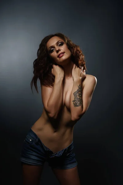 Изображение сексуальной девушки топлесс с татуировкой на руке — стоковое фото