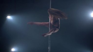 Güzel kadın dansçı kutubun dönen görünümünü