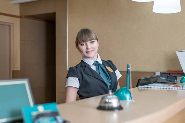 Friendly hotel worker posing behind reception — Stock Photo, Image