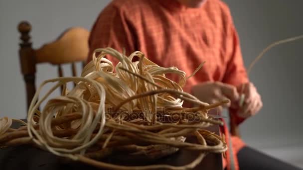 View of craftsman weaves basket in studio — Stock Video