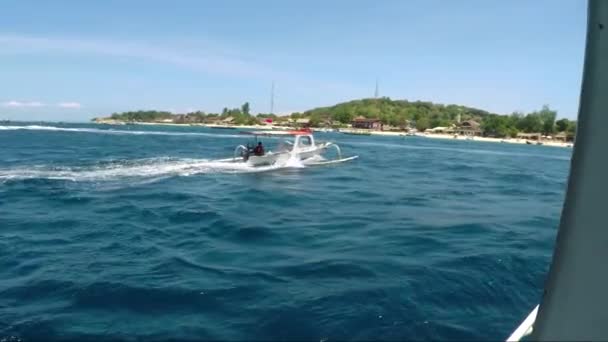 Vue d'un petit bateau avec un homme dedans et le littoral . — Video