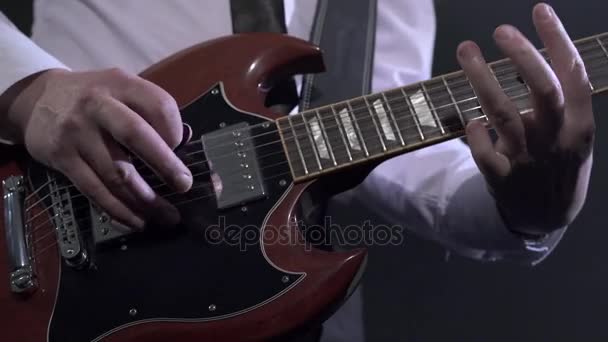 スタジオでギターを弾く白いシャツでギタリストのビュー. — ストック動画