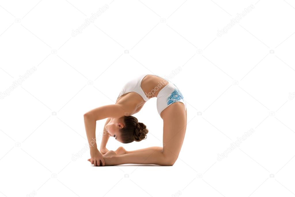 Young female gymnast bending gracefully backwards