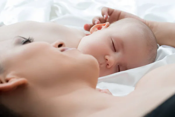 Bebé niño durmiendo y su mamá acostada sobre ropa blanca — Foto de Stock