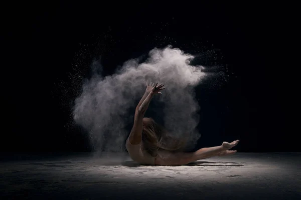 Gymnastka v ecru kombinézu v oblak bílého prachu — Stock fotografie